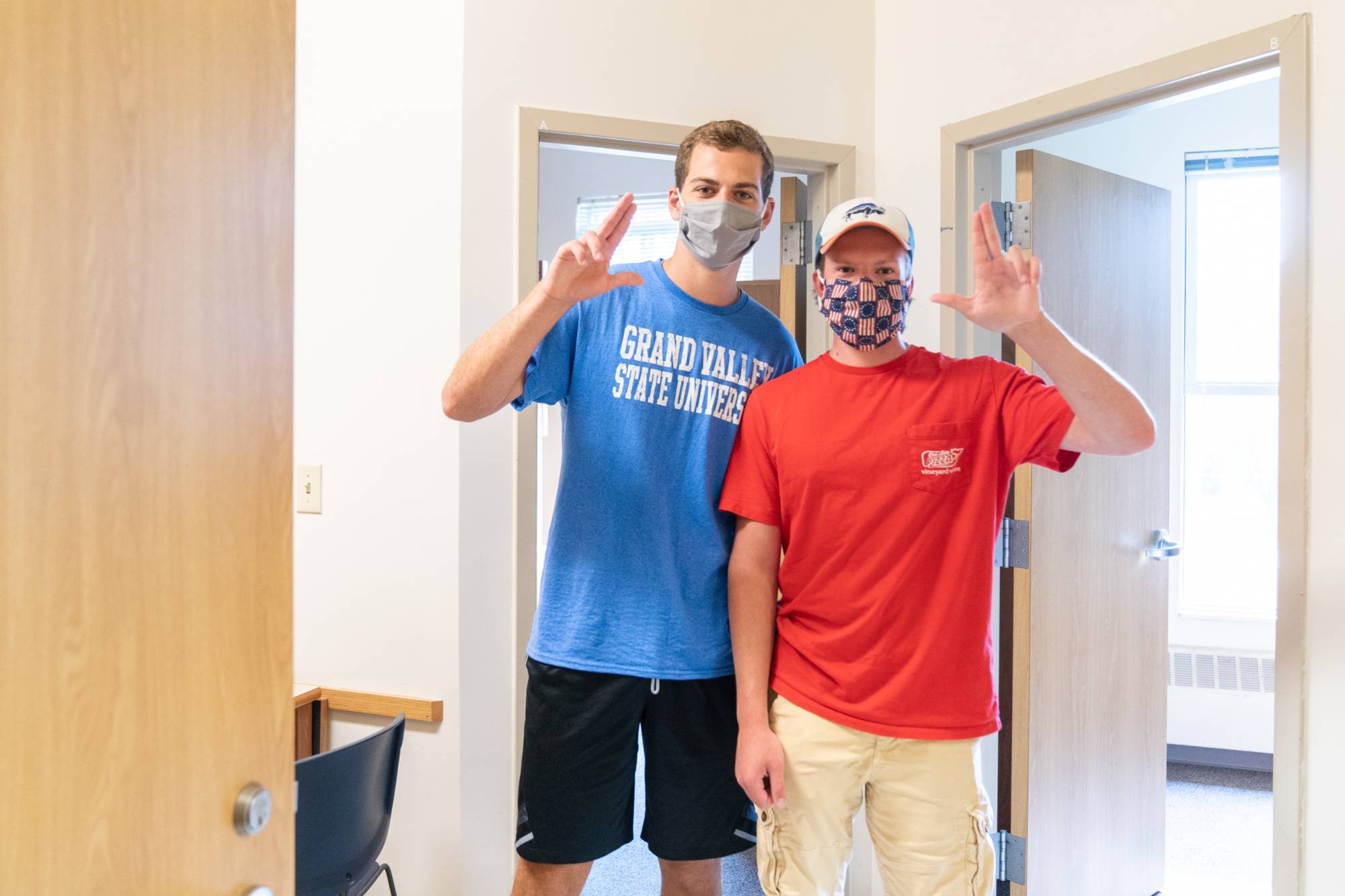 Two students standing outside of their room